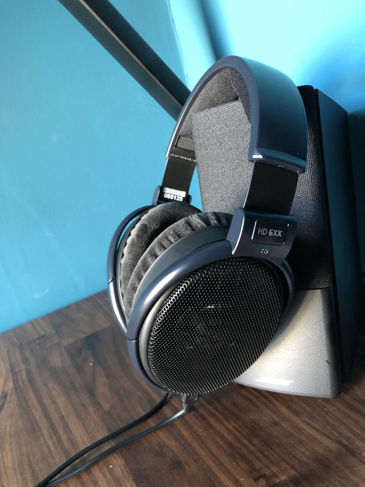 Sennheiser HD 6XX open-back headphones resting against a speaker on the desk.