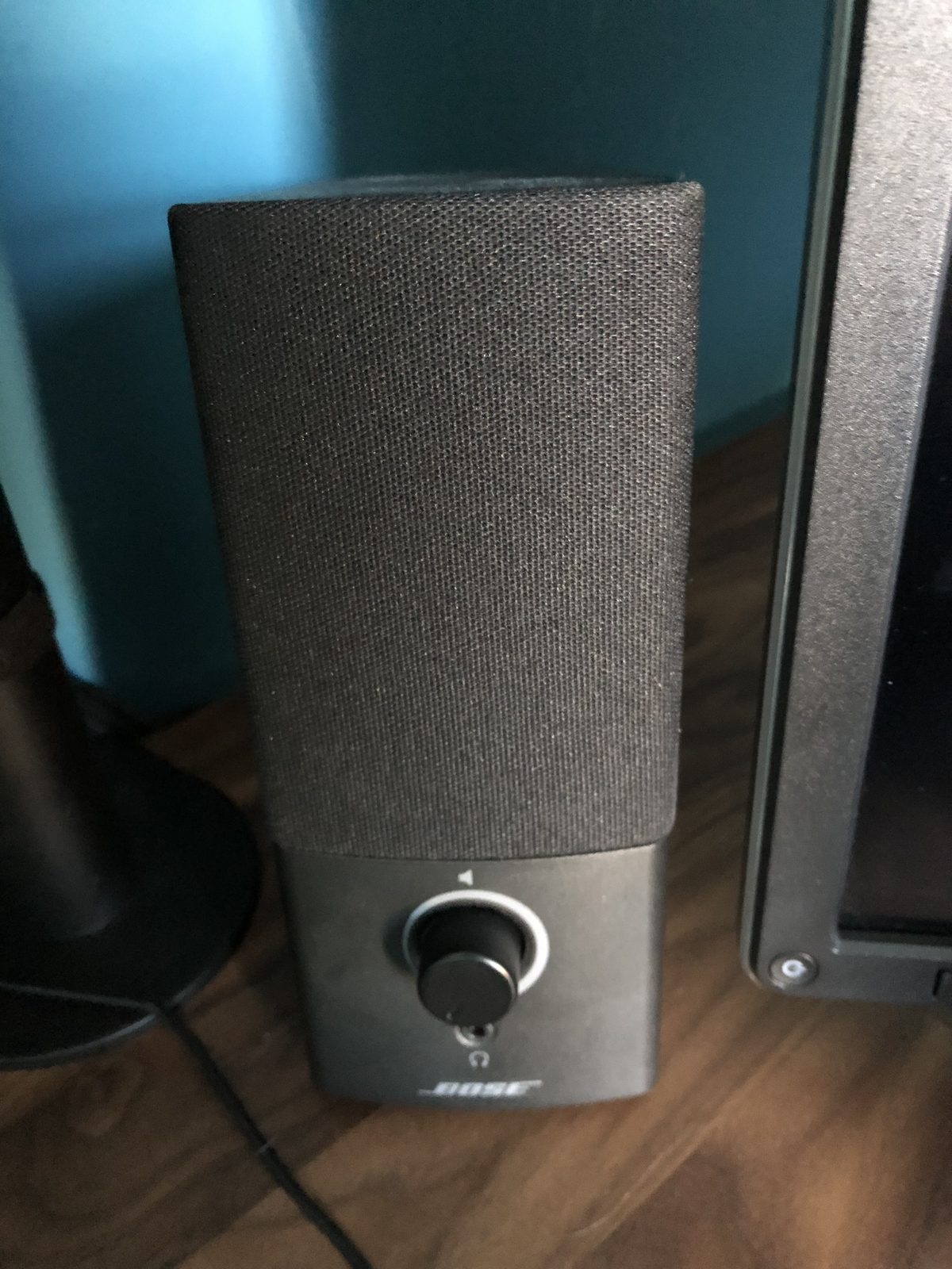 A small black Bose desktop speaker with a volume knob and headphone socket.